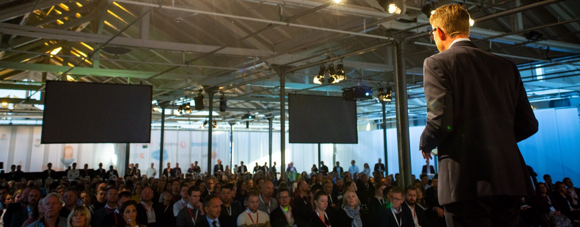 Tim Frank Andersen on stage in front of a large conference audience